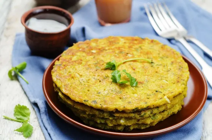Golden brown crispy moong dal chilla or pancake cooking on a hot iron tawa griddle Golden brown crispy moong dal chilla or pancake cooking on a hot iron tawa griddle