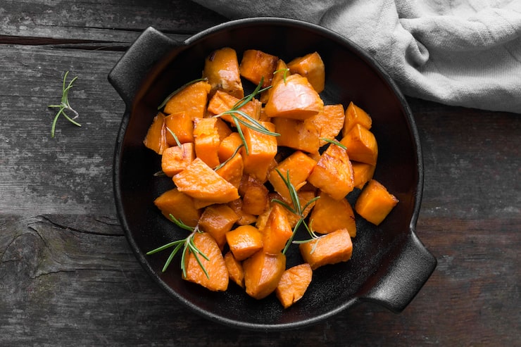 Close-up of sweet potato cubes pan-fried to a perfect golden-brown color in a skillet.