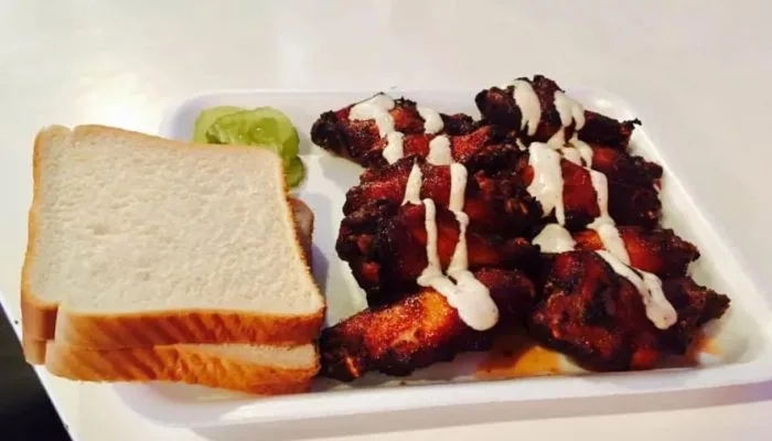 Close-up of a smoked chicken plate topped with Alabama white barbecue sauce served at SAW's Soul Kitchen. Close-up of a smoked chicken plate topped with Alabama white barbecue sauce served at SAW's Soul Kitchen.