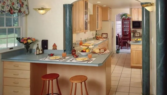 Suburban 1980s kitchen interior showcasing decorative classical columns and theatrical architectural accents. Suburban 1980s kitchen interior showcasing decorative classical columns and theatrical architectural accents.