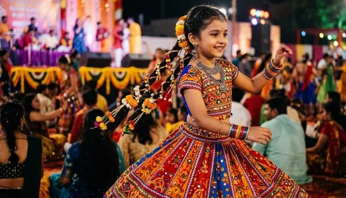 A girl wearing traditional Gujarati Garba hairstyle with two braids and flower ribbons A girl wearing traditional Gujarati Garba hairstyle with two braids and flower ribbons